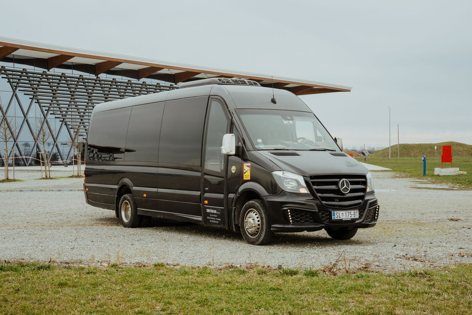 Sprinter s prednje desne strane ispred zgrade s rešetkastim pročeljem