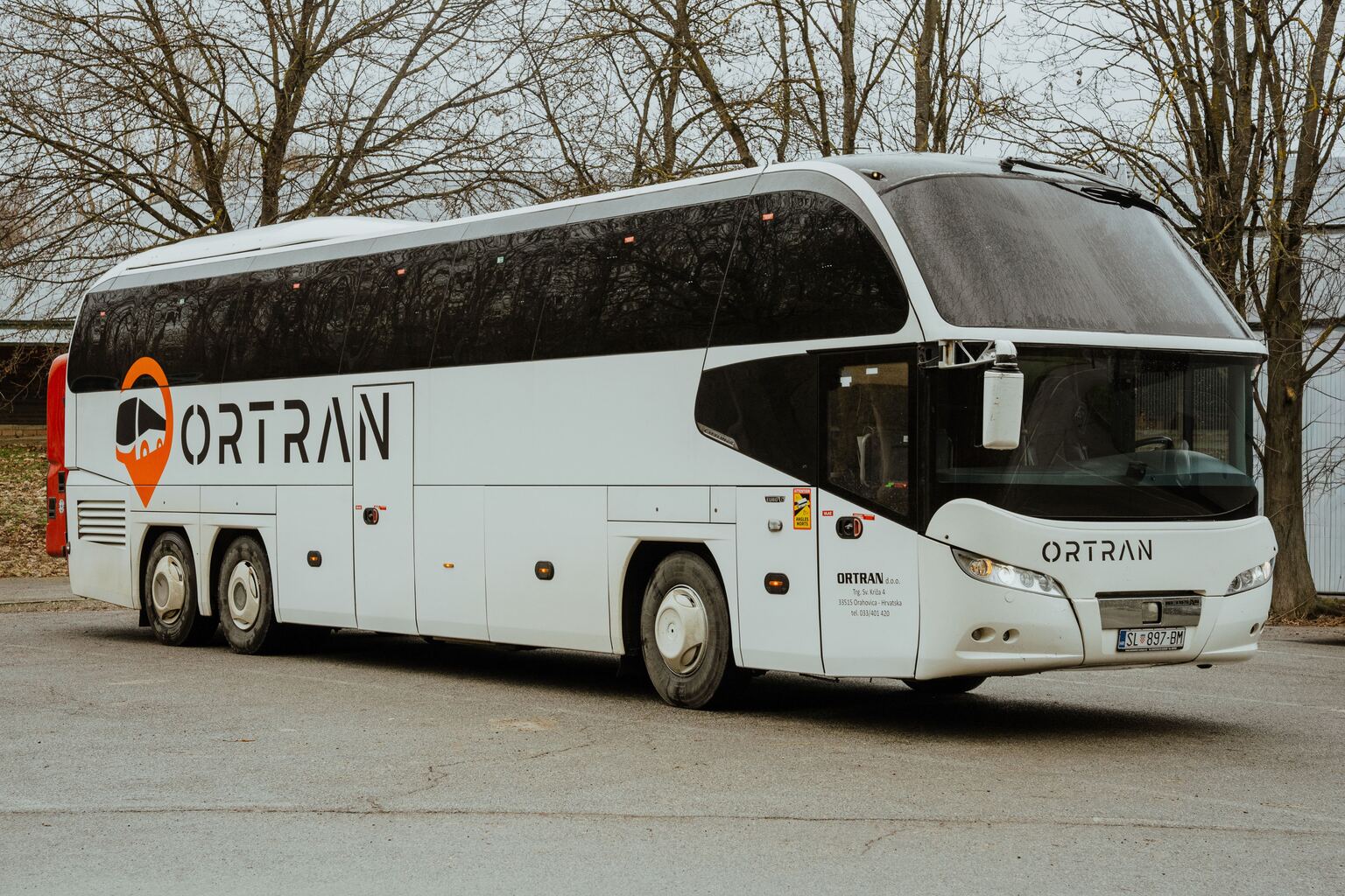 Bijeli autobus Neoplan Cityliner s Ortranovim logotipom, snimljen sprijeda iz tri četvrtine